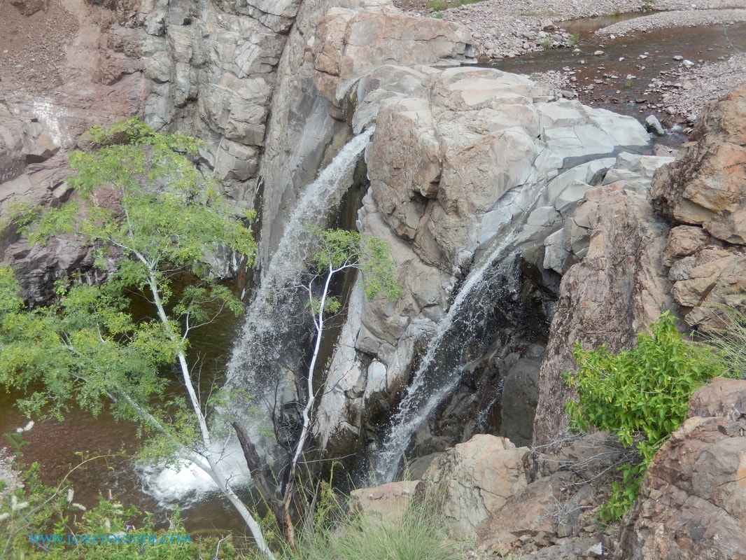 Group wading through a slot canyon pool on a guided hike near Loreto