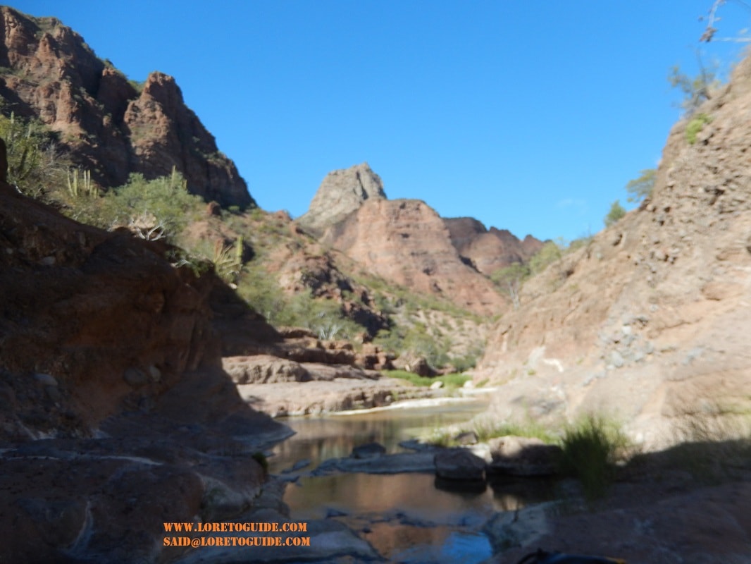 Double waterfall viewed through a natural rock window in a Loreto canyon