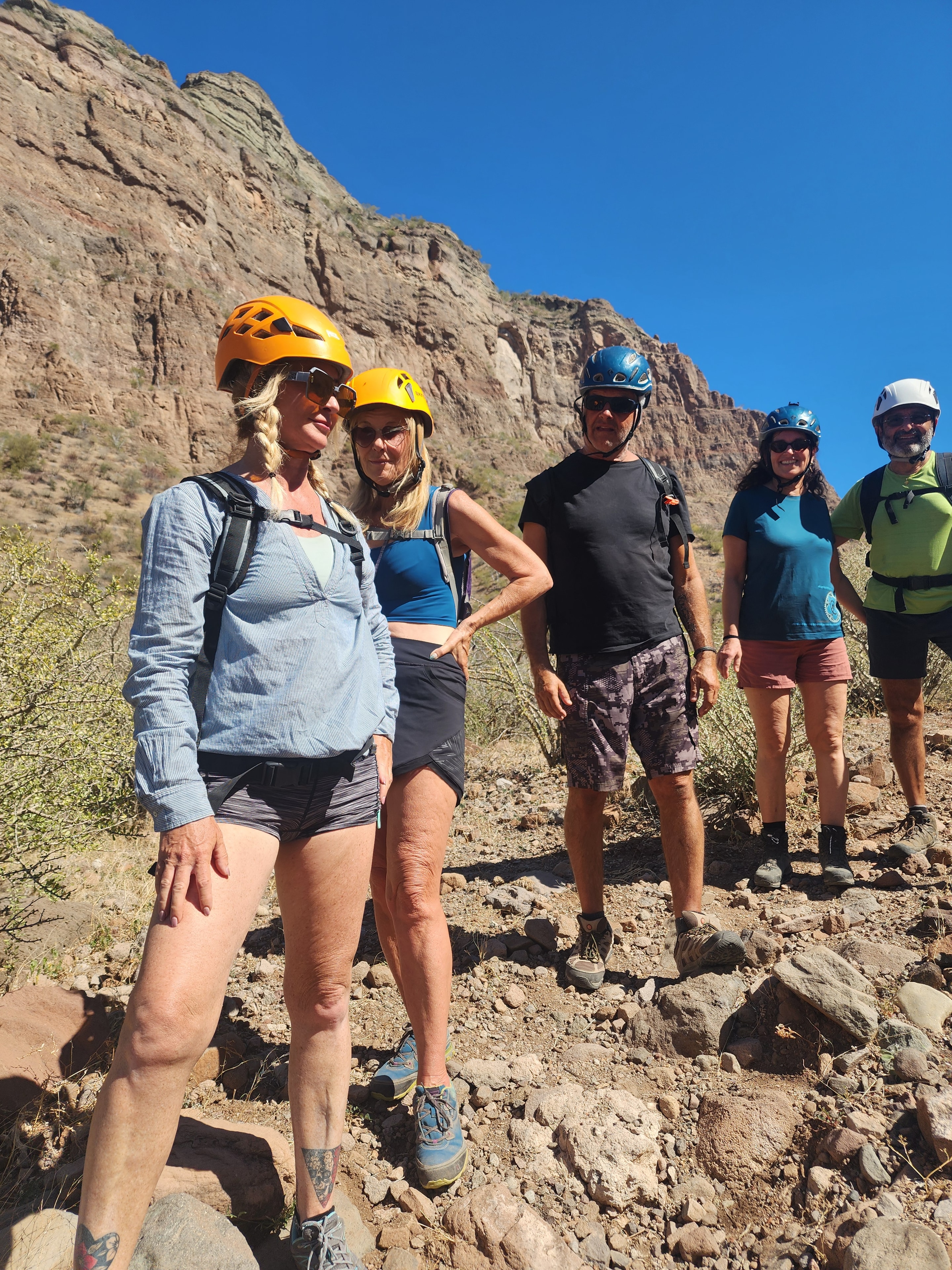 Hiking group with helmets posing against a canyon wall near Loreto